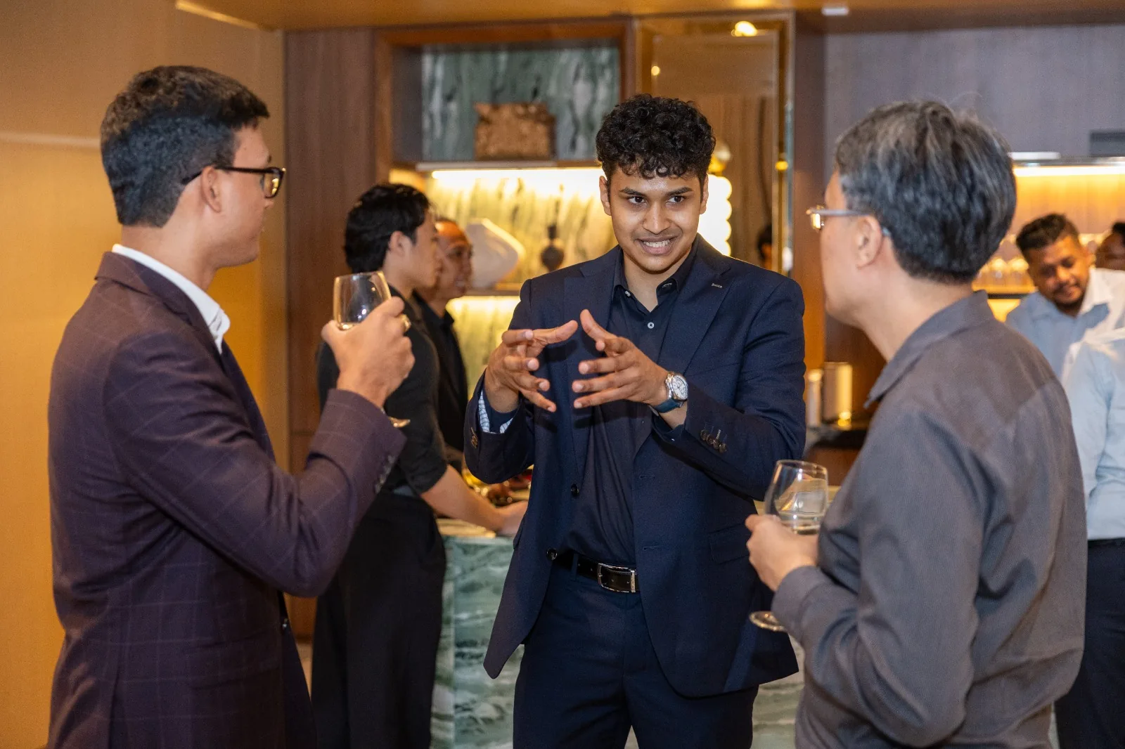 A guest talking with two others during the launch reception