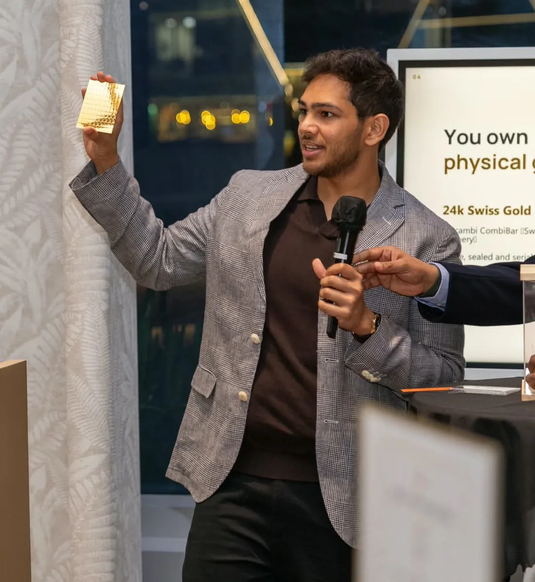 Anirudh Menon holding up a gold CombiBar at the FinMet.sg launch